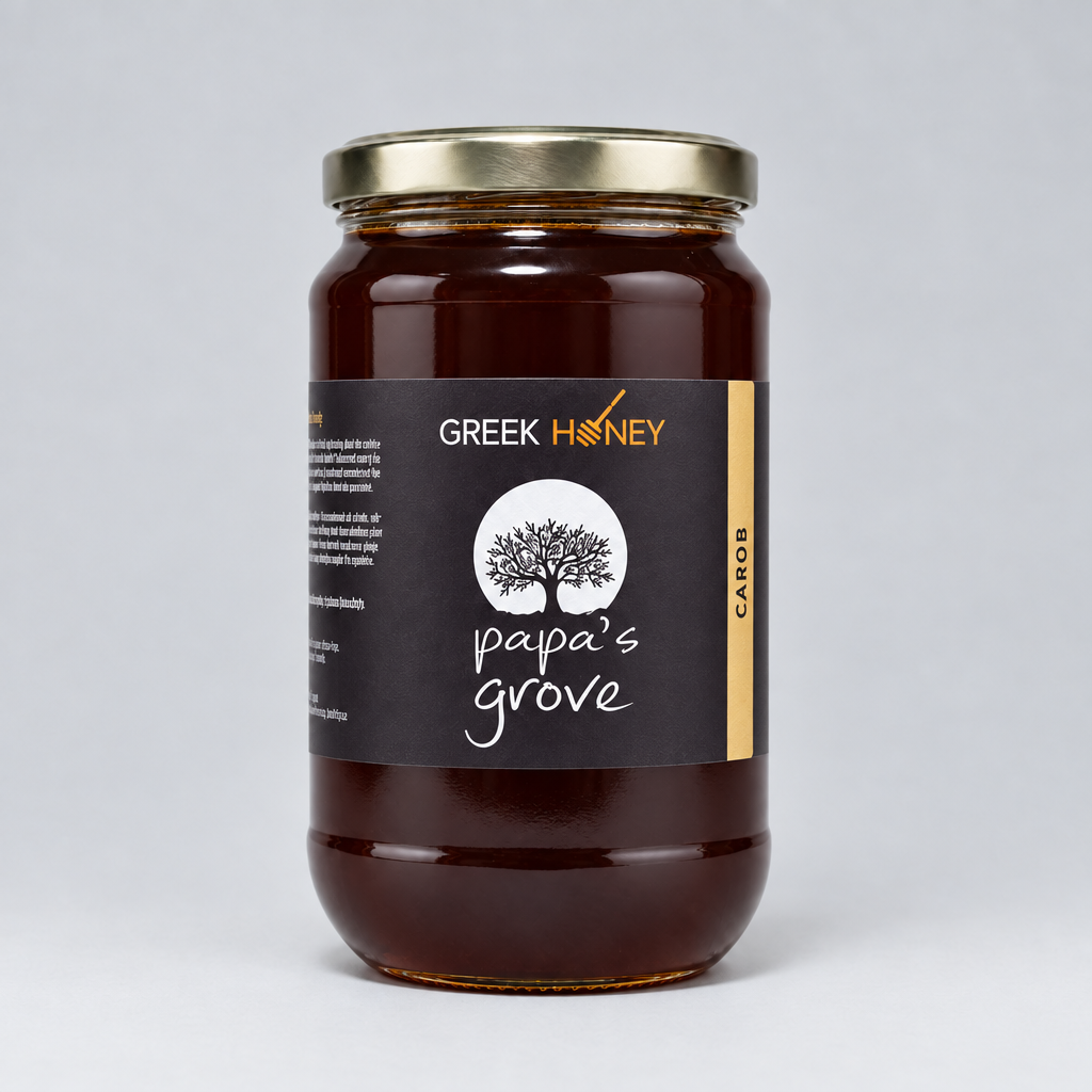 A tall glass jar of Greek Honey from Papa's Grove, filled with dark amber honey and featuring a black label with a white tree logo and a silver metal lid, set against a neutral gray background.