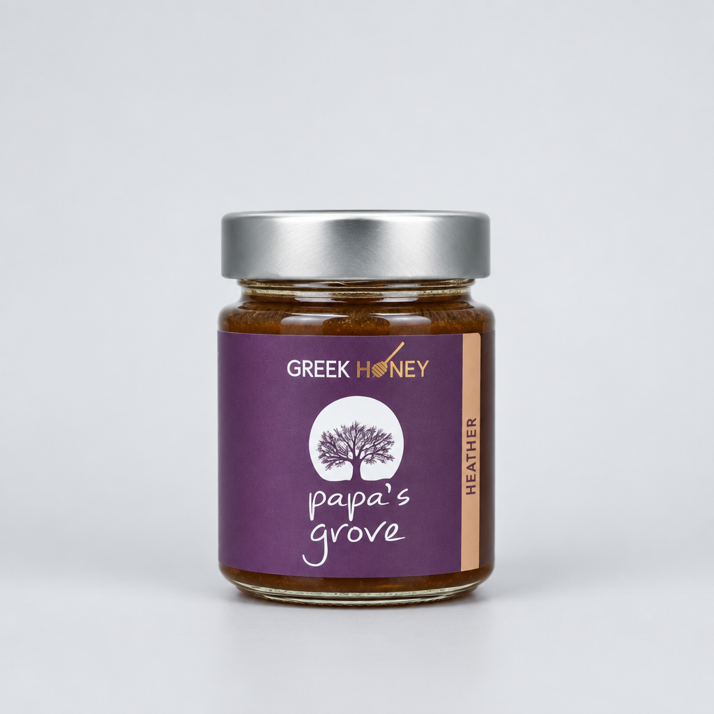A glass jar of Greek Raw Heather Honey from Papa's Grove, featuring a purple label with a tree logo and a sliver metal lid, set against a neutral gray background.
